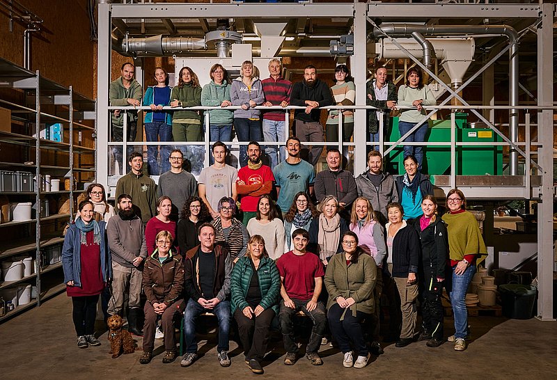 ReinSaat Team 2024 - Gruppenbild flankiert von Gewächshäusern